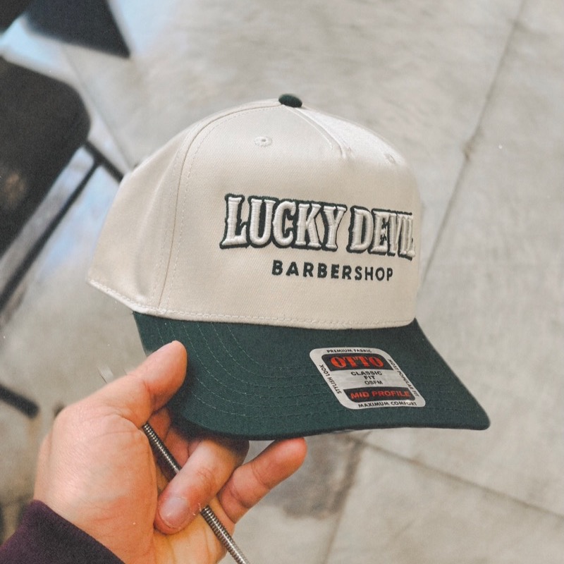 Lucky Devil Barbershop snapback hat, cream crown with green brim
